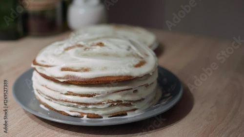 Woman placing a sponge layer on a cake, woman assembling a cake
