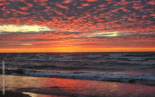 Фотография An intense sunset with deep orange and red hues reflecting over Lake Michigan