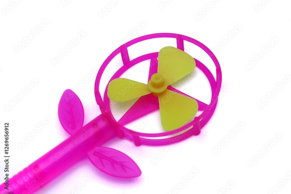 Pink plastic toy fan with green blades on a clean white background Pink plastic toy fan with green blades on a clean white background