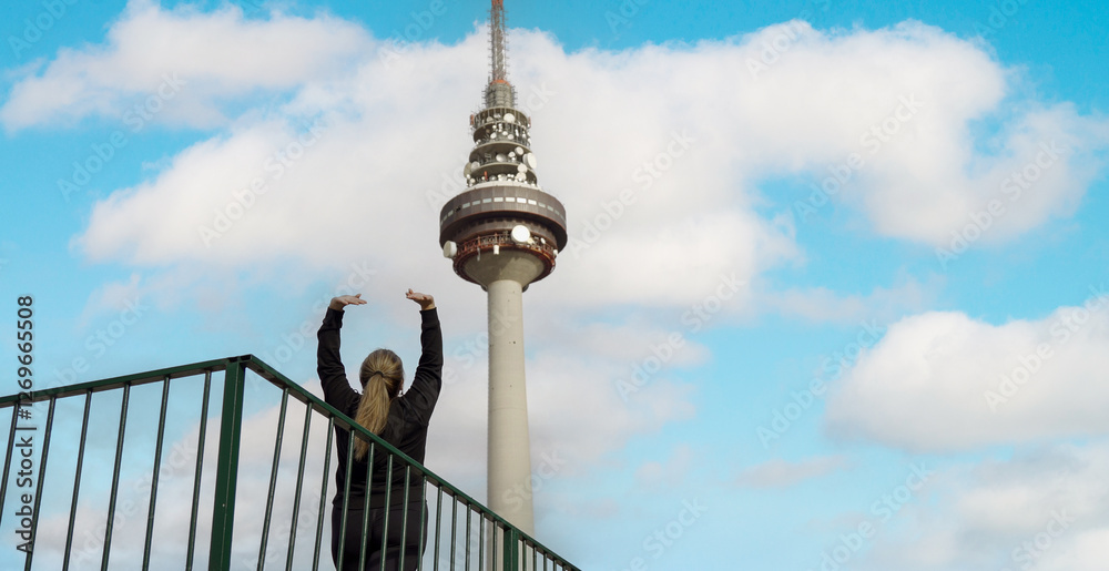 Woman stretching with madrid's piruli tower in the background