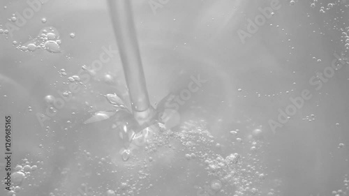 Thin trickle of transparent cosmetic gel with tiny bubbles flows down to the surface. Transparent liquid gel background, transparent serum texture. Cosmetic skin care product. top view