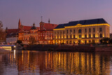 Zachód słońca w mieście - Wrocław zachód słońca z widokiem na rzekę Odrę, budynki i niebo.