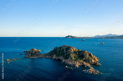 Boats in front of the Isola dell Ogliastra islands in Lotzorai in Europe, Italy, Sardinia, Lotzorai, in summer, on a sunny day. photo