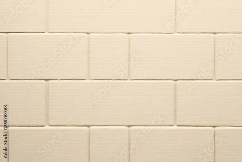 smooth, light colored tile wall featuring rectangular tiles arranged in classic pattern, perfect for modern interiors. subtle texture adds depth and warmth to any space