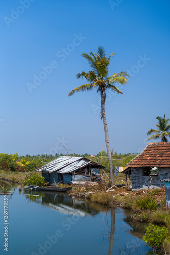 Canvas Print The house on the shore of Astamudi Lake in Munroe Island in Asia, India, Kerala, Munroe Island, in summer, on a sunny day