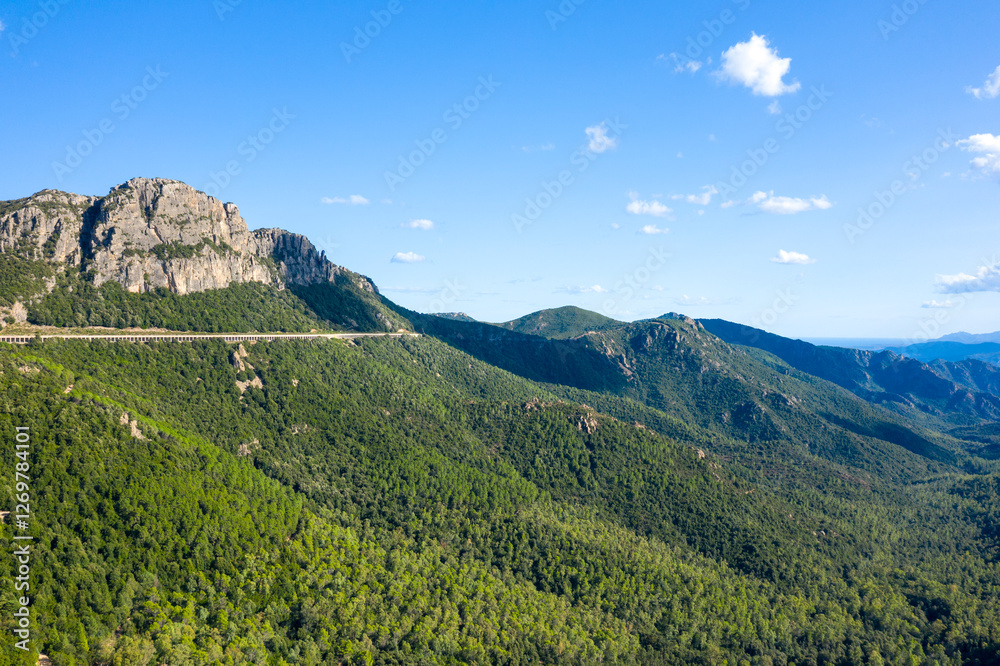Fototapeta premium The road in the Sardinian countryside between Baunei and Dorgali in Europe, Italy, Sardinia, Baunei, in summer, on a sunny day.