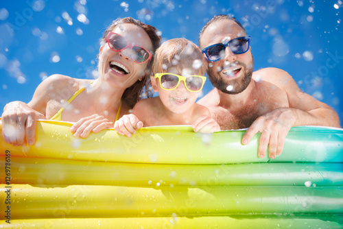 Happy family playing in waterpark. People having fun on summer vacation