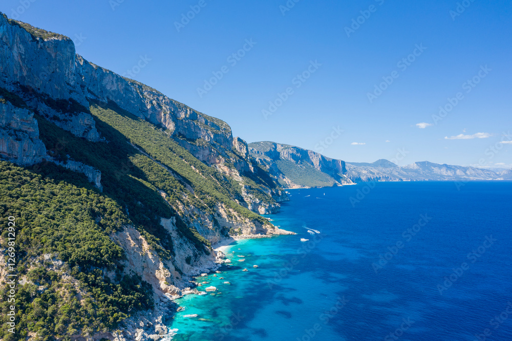 Fototapeta premium The cliffs around Cala Goloritze beach in Baunei in Europe, Italy, Sardinia, Baunei, in summer, on a sunny day.