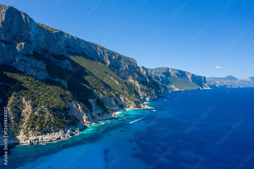 Obraz premium The cliffs around Cala Goloritze beach in Baunei in Europe, Italy, Sardinia, Baunei, in summer, on a sunny day.