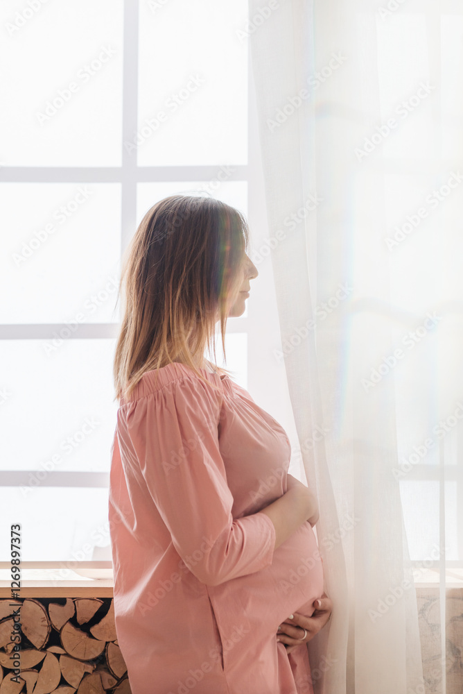 Portrait shot of young beautiful woman on third trimester of pregnancy. Close up of pregnant female with arms on her round belly. Expecting a child concept. Background, copy space. Portrait shot of young beautiful woman on third trimester of pregnancy. Close up of pregnant female with arms on her round belly. Expecting a child concept. Background, copy space.