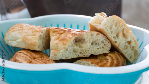 Golden Crusted Traditional Bread in a Wicker Basket with Soup in the Background