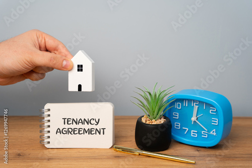 Tenancy agreement concept. Legally binding contract between a landlord and a tenant, outlining the terms and conditions under which the tenant can occupy the property. Notes and house with man photo