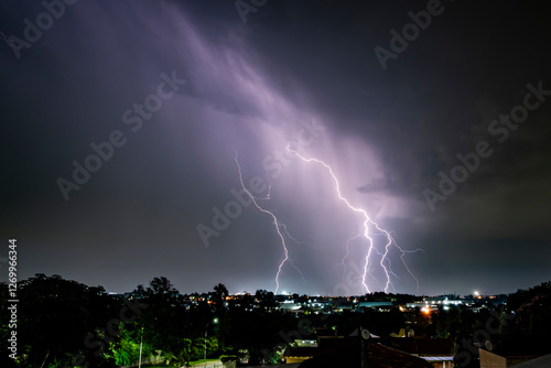 A dramatic photograph capturing powerful lightning strikes illuminating the dark sky. The jagged bolts of electricity contrast against the storm clouds, creating a breathtaking natural spectacle.