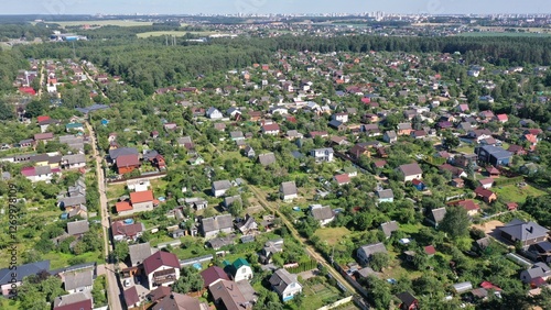 An aerial view of the suburb with residential private cottage development. Suburb of Minsk. Low-rise building against the background of the metropolis.