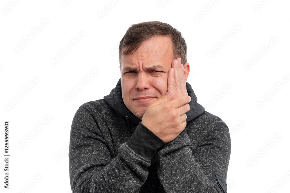 A young man grimacing while holding his jaw, expressing discomfort against a white background. A young man grimacing while holding his jaw, expressing discomfort against a white background.