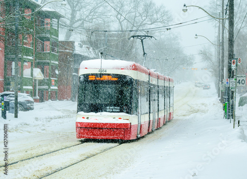 public transit: streetcar moving on a Toronto street during a winter snow storm shot in the Beaches neighbourhood