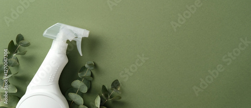 White spray bottle with eucalyptus leaves on a green background, ideal for eco-friendly cleaning product advertisements or natural home care promotions
