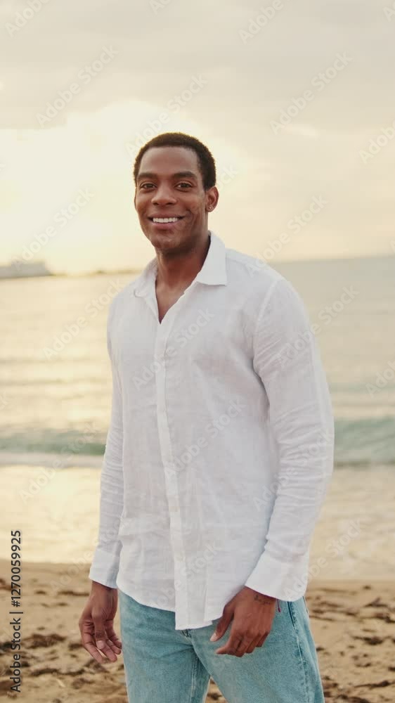 Vertical video, Handsome young man enjoying the beautiful sunset on the beach. He looks happy and relaxed. Perfect for travel, lifestyle, and tourism content. Vertical video, Handsome young man enjoying the beautiful sunset on the beach. He looks happy and relaxed. Perfect for travel, lifestyle, and tourism content.