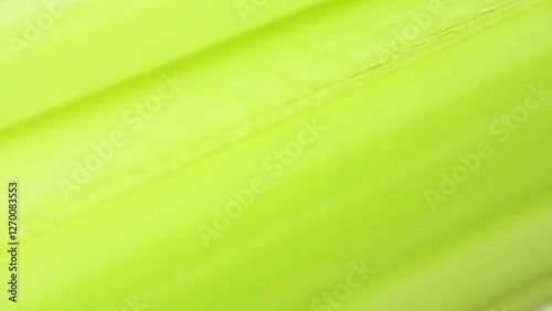 A close-up of celery's fibrous, stringy texture with pale green stalks. Lighting emphasizes its intricate and moist surface.