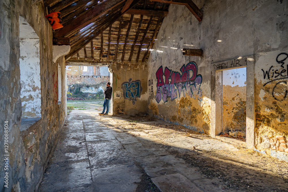 Fototapeta premium 40-year-old white European man among the ruins of an old abandoned and vandalized cork factory in the city of Barreiro, Portugal.