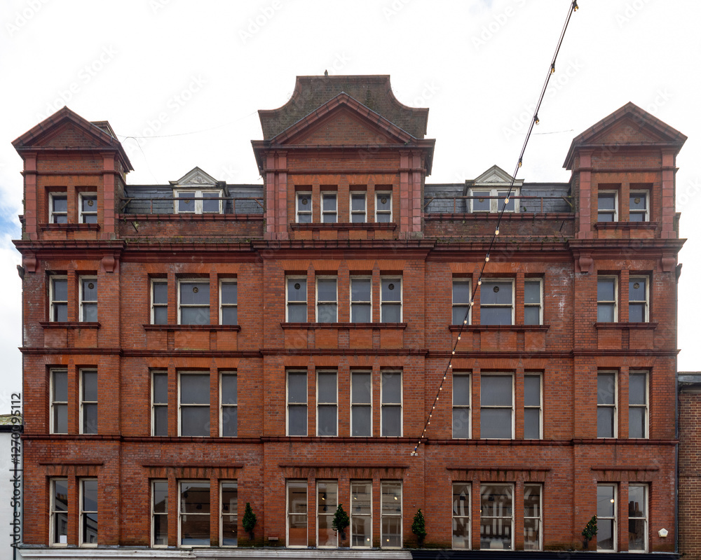 Fototapeta premium A detailed view of the Salisbury Building, showcasing its red brick facade and symmetrical architectural design. The structure features decorative gables