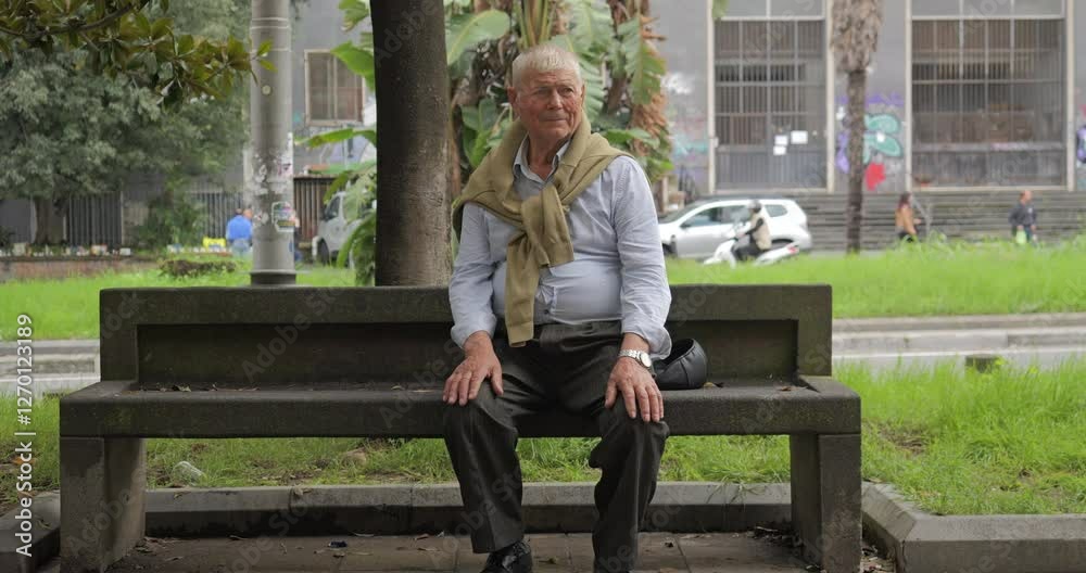 Old man rests on a bench in the city