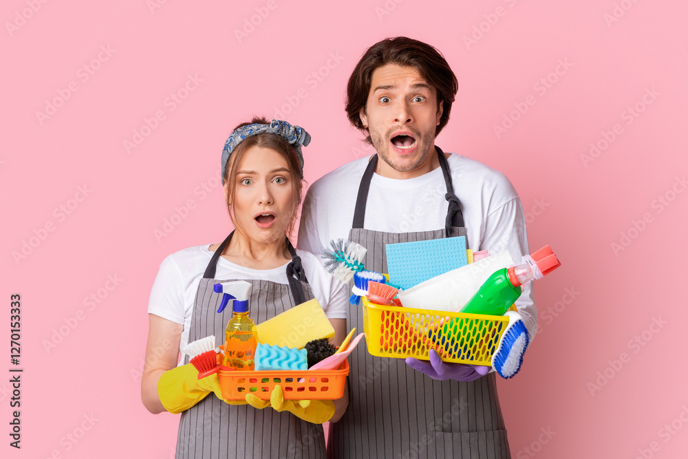 Household Chores. Portrait Of Shocked Couple Holding Buckets With Cleaning Supplies And Standing With Open Mouth Over Pink Background Household Chores. Portrait Of Shocked Couple Holding Buckets With Cleaning Supplies And Standing With Open Mouth Over Pink Background