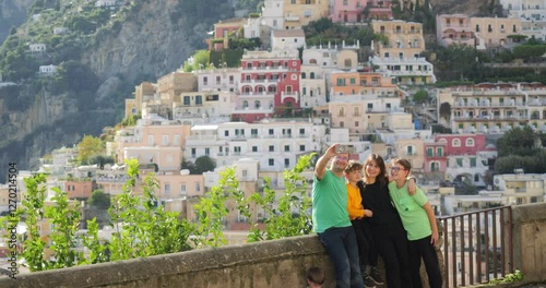 Happy young family takes selfies in front of Positano on Amalfi Coast in Italy