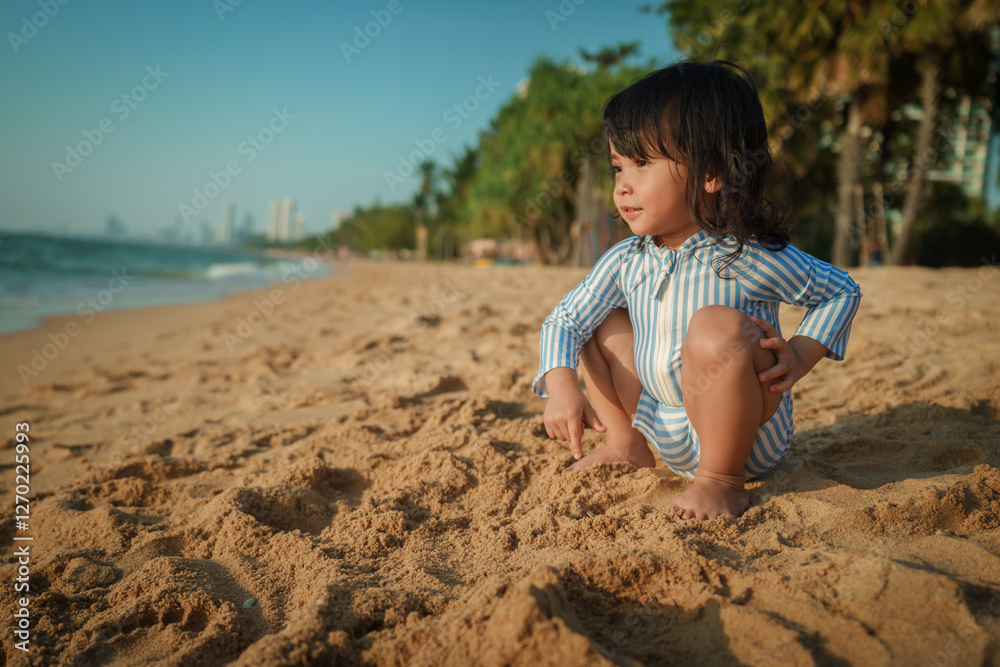 toddler baby girl sitting on sea beach in Pattaya, Thailand toddler baby girl sitting on sea beach in Pattaya, Thailand