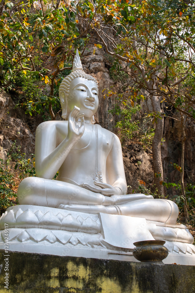 A large silver Buddha statue is enshrined in a natural forest. A large silver Buddha statue is enshrined in a natural forest.