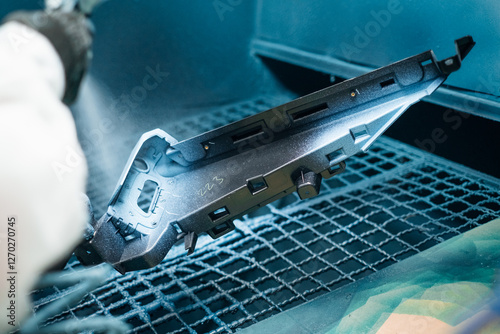 A part being spray painted with a protective coating in an industrial setting Surface finishing process