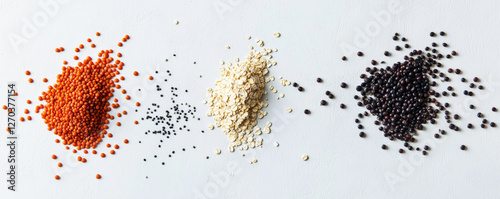 Colorful assortment of grains including red lentils, black beans, oats, and black lentils arranged in flat lay. Perfect for healthy meal preparation and nutrition