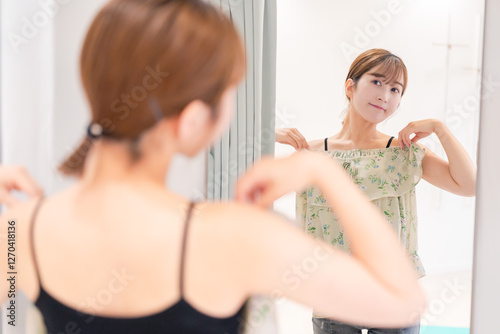 Foto 試着室で服の試着をする若い女性