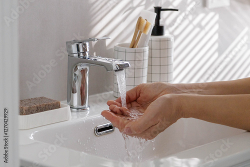 Woman washing female hands close up in washbasin with clean running water.