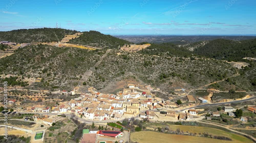 Canada de Verich Village. Aerial view of small isolated village in Teruel Province, Aragon, Spain. Surrounded by agriculture fields and hills. Travel destination for cyclists. Drone going backwards Canada de Verich Village. Aerial view of small isolated village in Teruel Province, Aragon, Spain. Surrounded by agriculture fields and hills. Travel destination for cyclists. Drone going backwards