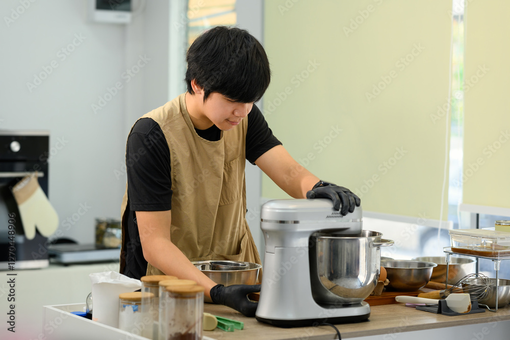 Asian baker using stand mixer to prepare cookie dough in a modern kitchen Asian baker using stand mixer to prepare cookie dough in a modern kitchen