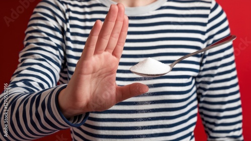 Person rejects sugar on a spoon with hand gesture