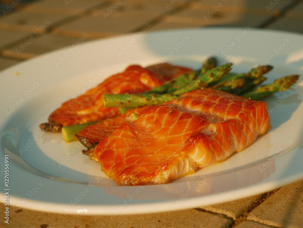 Grilled salmon with asparagus on white plate in natural light Grilled salmon with asparagus on white plate in natural light