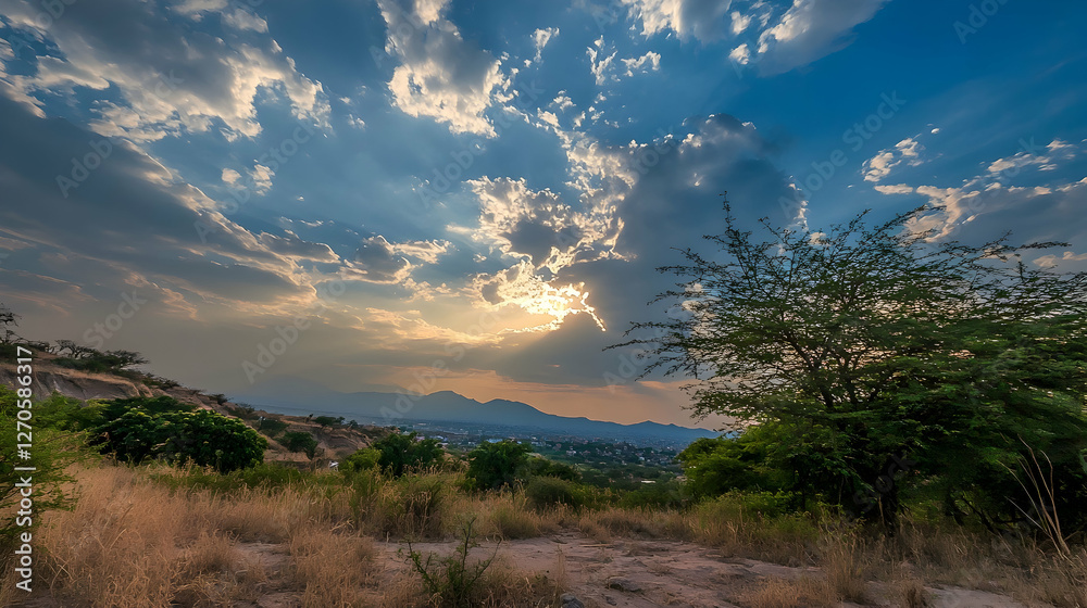 Sunset over hills, city vista, sun rays