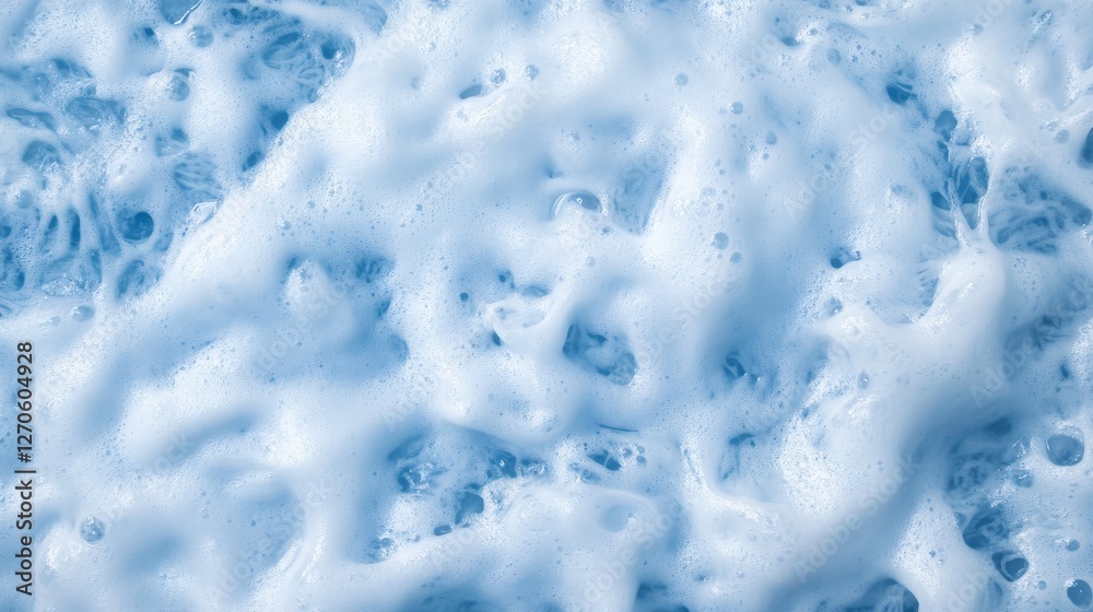 Obraz premium Powerful ocean waves break into frothy white crests, creating a mesmerizing pattern on the deep blue water with open space on the right for potential text