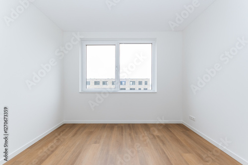 interior empty basic bedroom in modern new build residential smart house. Glass window is neighboring building over the road. Plain white walls and wood effect vinyl flooring make blank canvas