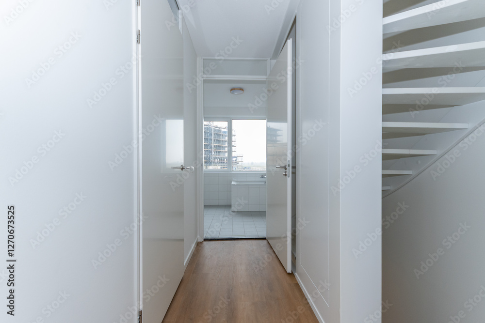 interior unfurnished empty basic stairway corridor landing to bathroom in modern new build residential smart house. Glass window view. Plain white walls and wood effect vinyl flooring blank canvas interior unfurnished empty basic stairway corridor landing to bathroom in modern new build residential smart house. Glass window view. Plain white walls and wood effect vinyl flooring blank canvas