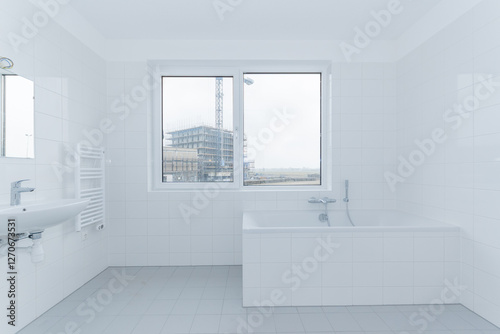 interior clean white tiled bath and bathroom of modern new build residential smart house looking through window at further development phase of project construction site building in scaffolding photo