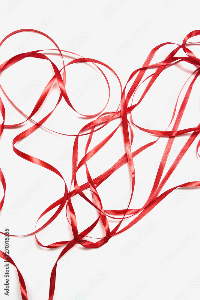 Curled red ribbons form a heart shape on a white background, perfect for decorations and crafts Curled red ribbons form a heart shape on a white background, perfect for decorations and crafts