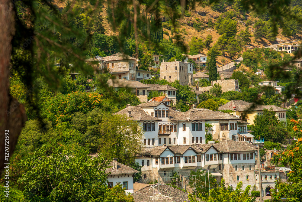 Fototapeta premium Enchanted Hillsides of Gjirokaster: Albania’s Historic Ottoman-Era Stone City Overlooking Verdant Slopes and the Drino Valley’s Balkan Legacy