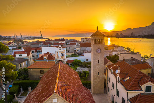 A picturesque view from the center of Vranjic, Croatia, at sunset, showcasing its charming Mediterranean streets, historic architecture, and the Adriatic Sea, creating a romantic coastal atmosphere