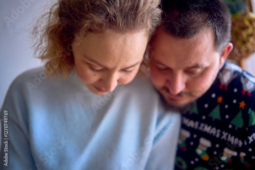 a husband and wife are cooking Christmas cookies in the kitchen photo