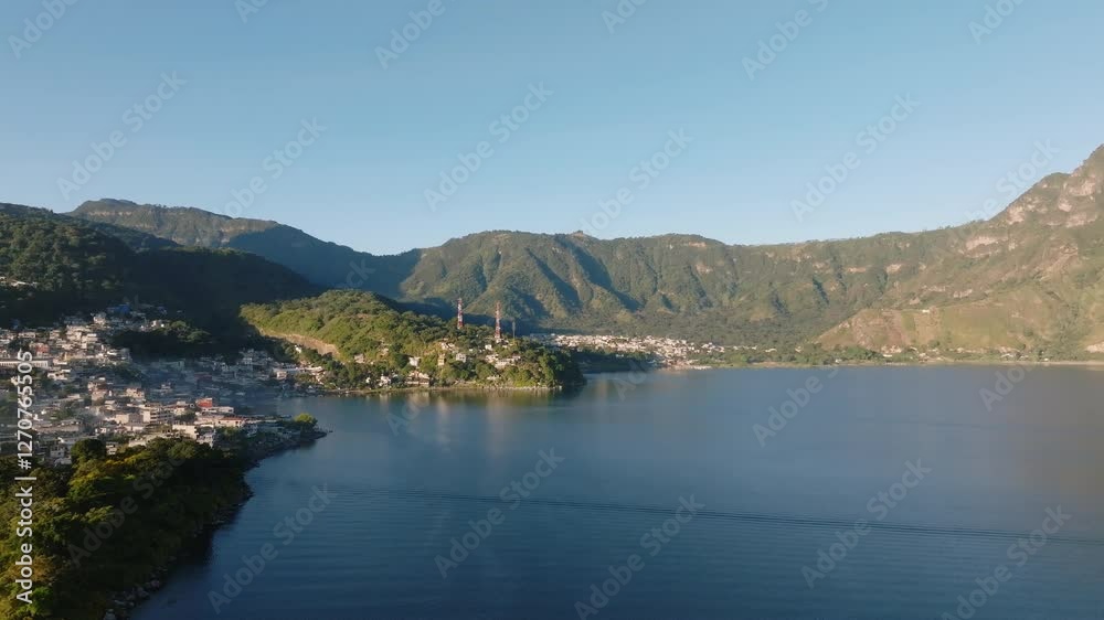 Breathtaking misty sunrise over San Pedro La Laguna, Lake Atitlan. Golden light, calm waters, and volcanic silhouettes create a magical morning scene.