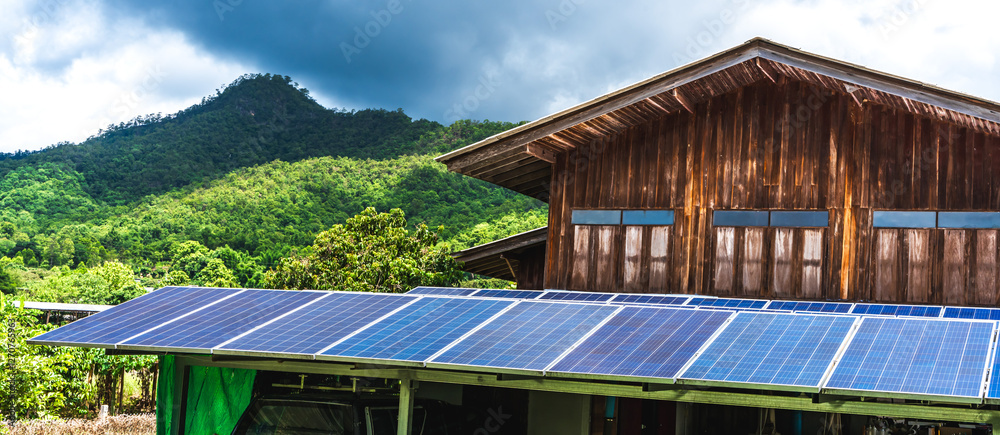 Solar panels on the roof of a house near mountain Solar panels on the roof of a house near mountain