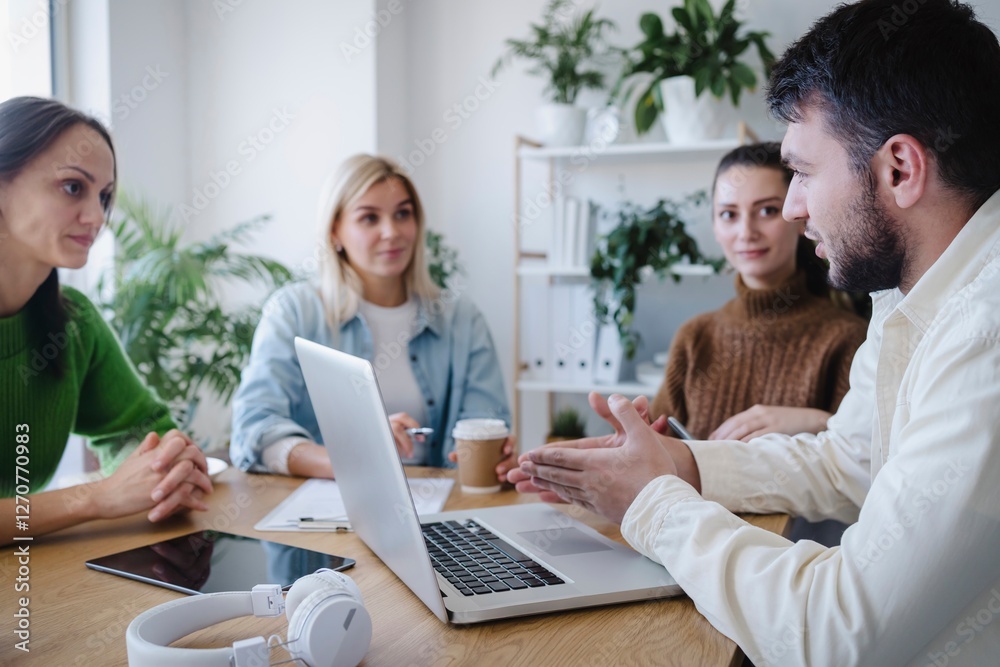 Young businessman gesturing and explaining strategies at meeting